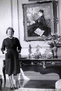 Eleanor Ford stands in front of a portrait in Ford House.