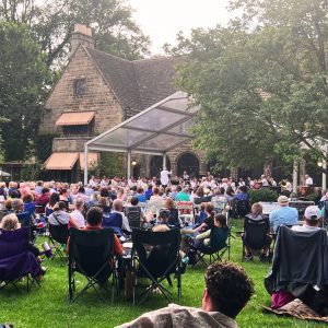 Hundreds of guests gather on the lawn at Ford House for an outdoor concert.