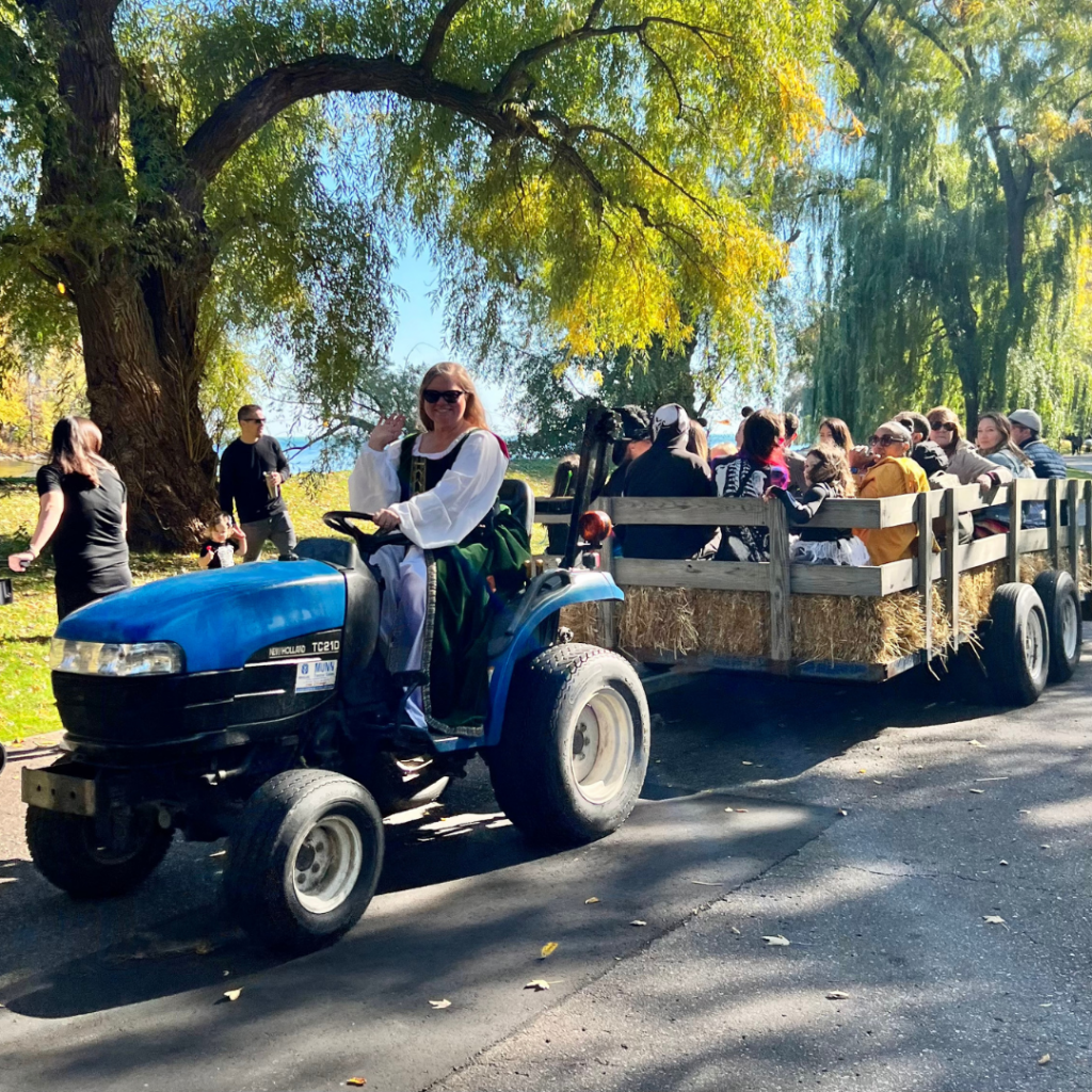 A tractor is pulling a trailer filled with people for a hay ride.